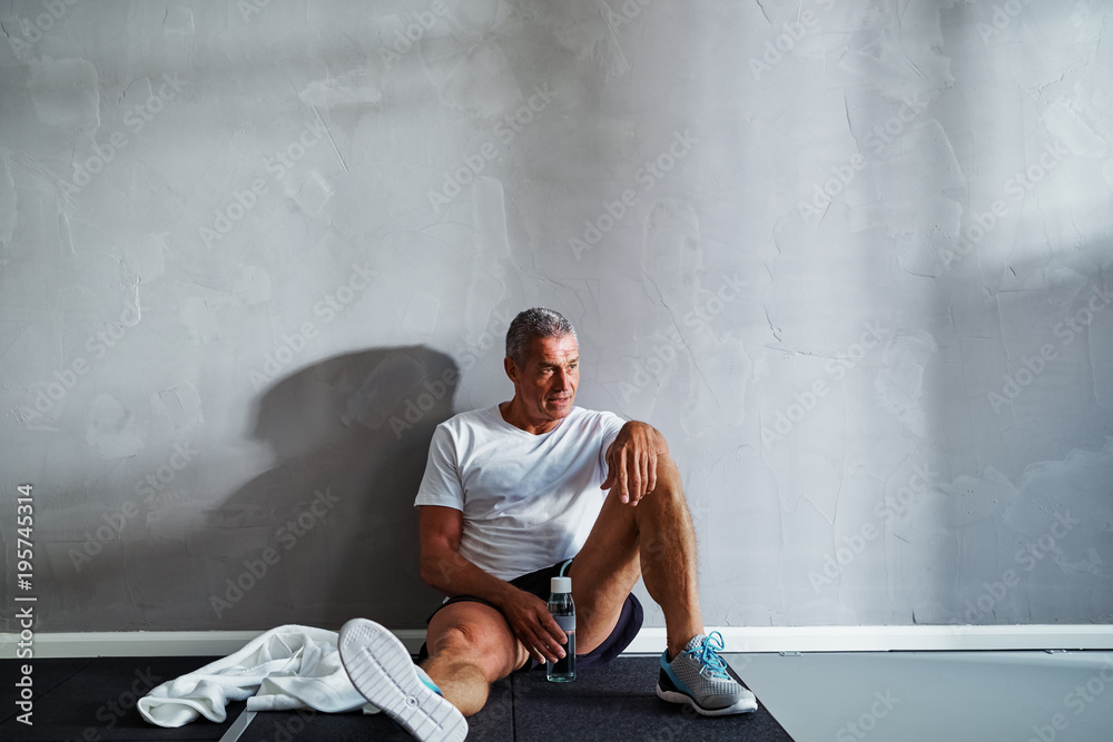老年人锻炼后在健身房地板上休息