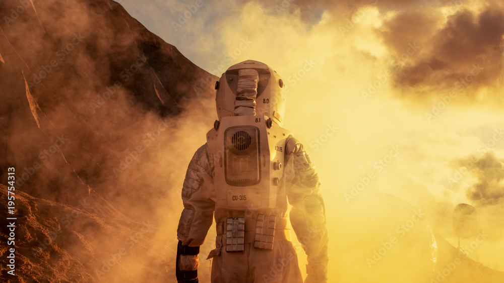 身穿太空服的勇敢宇航员探索笼罩在薄雾中的红色星球火星。冒险。太空旅行