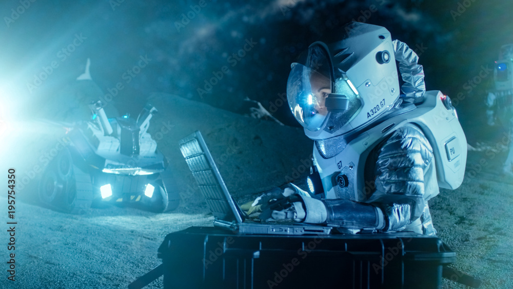 Female Astronaut Wearing Space Suit Works on a Laptop, Exploring Newly Discovered Planet, Communicat