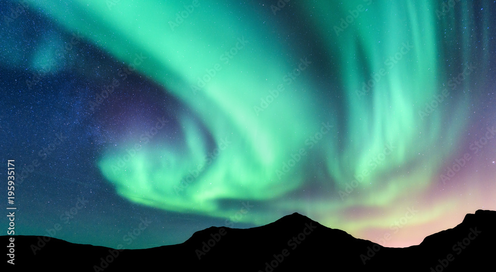 北极光和山脉的轮廓。挪威罗弗敦群岛。极光。绿色和紫色的北方