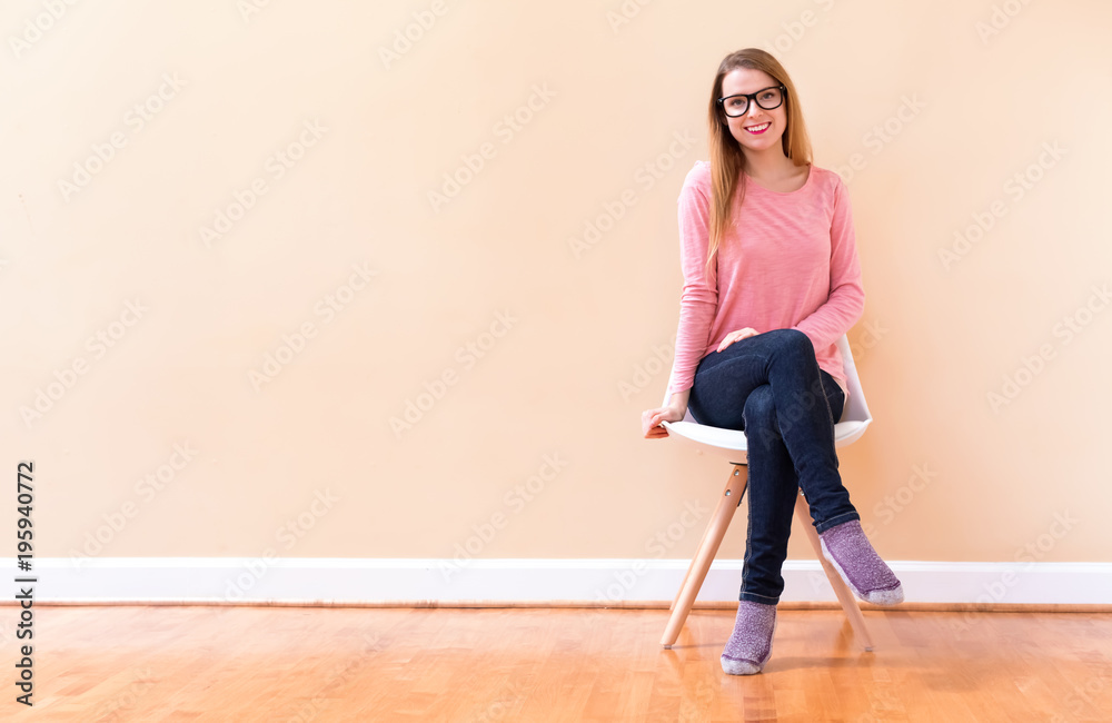 Happy young woman smiling while sitting in a big open room