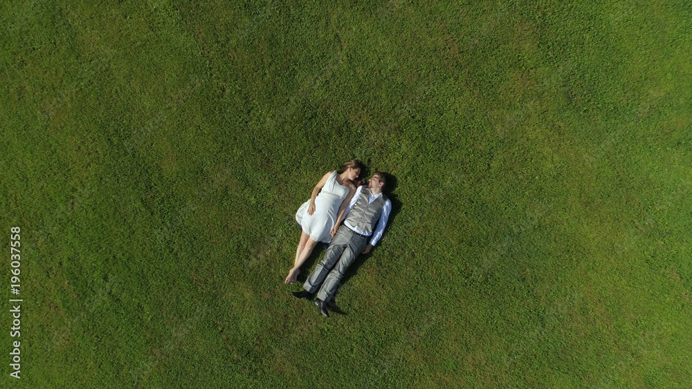空中俯视快乐的父母手牵着手在田野里并肩放松