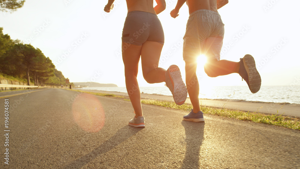 阳光灿烂：一对不知名的慢跑夫妇享受着温暖的夏日午后阳光。