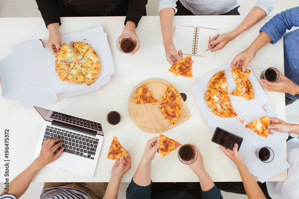 午餐和人的概念。快乐的商业团队在办公室吃披萨