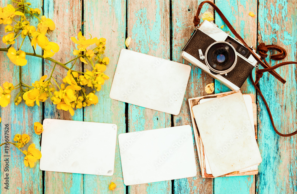 复古相机和空的旧即时纸相册，放在带有花卉边框设计的木桌子上-conc