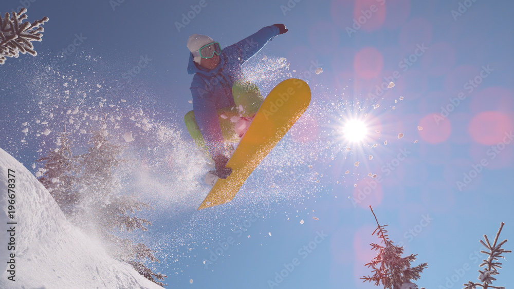 太阳耀斑，特写：兴奋的单板滑雪运动员在偏远山区跳过太阳