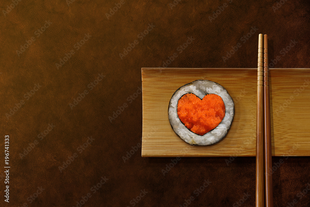 日本美食爱好者概念。心形寿司卷，装在木板和筷子上食用。Topvi
