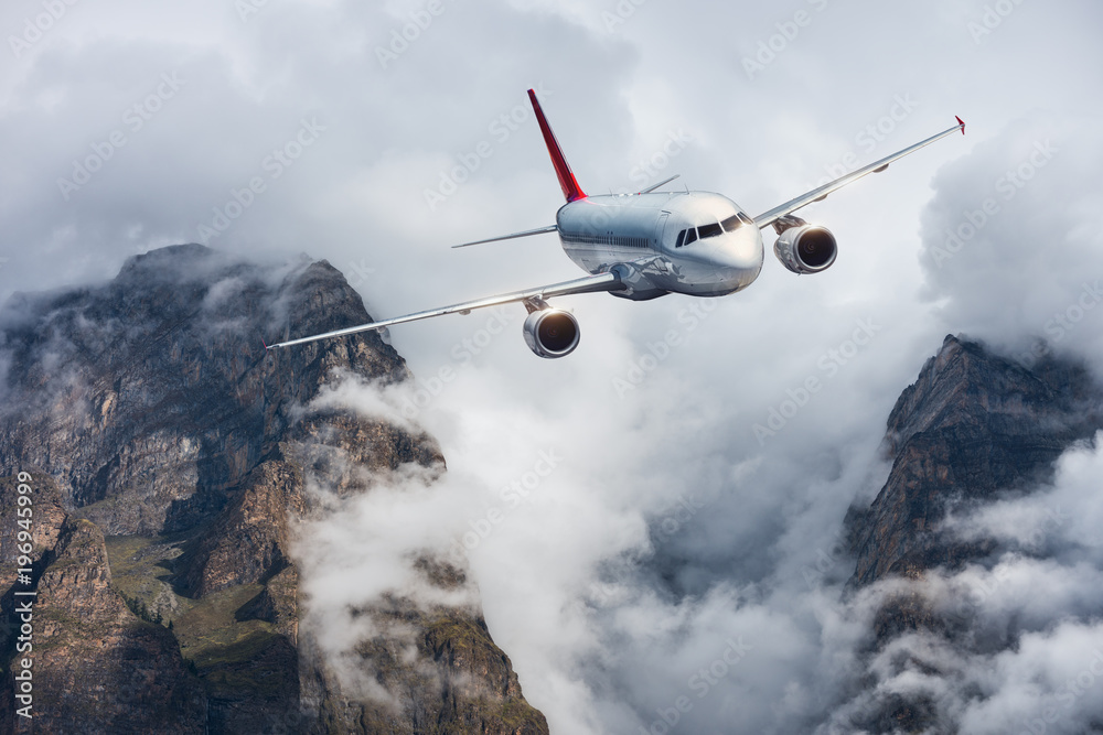 飞机，阴天中的山脉。飞机在高山的云层中飞行。风景