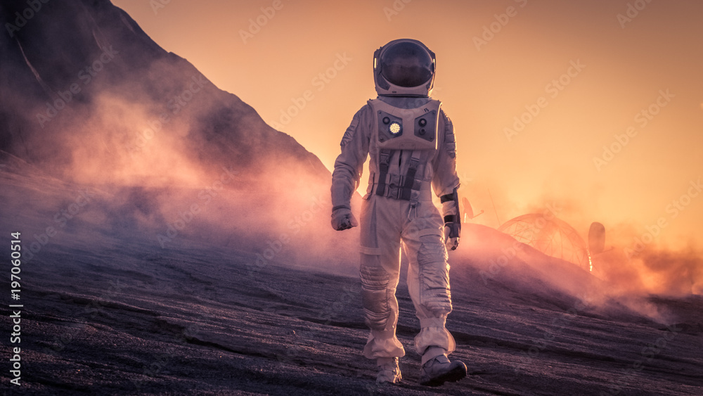 日落时，身穿太空服的宇航员在红色星球/金星上行走。背景是他的基地