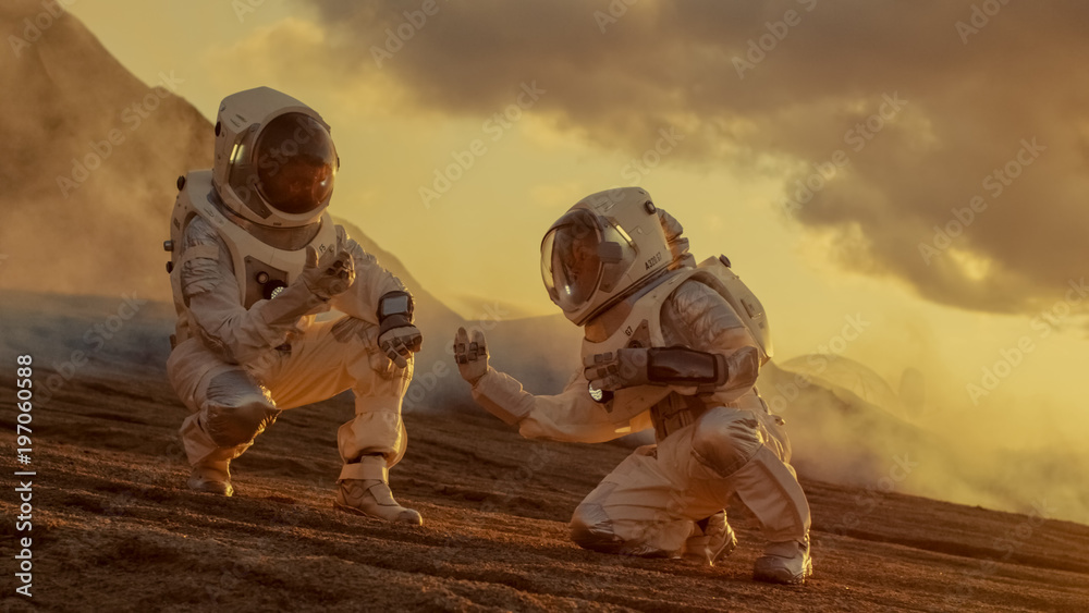 两名宇航员在外星行星上收集土壤样本，并用手持电脑进行分析。火星/红色