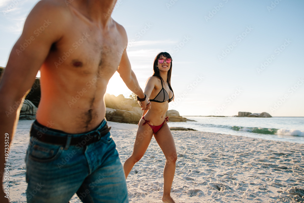恋爱中的情侣沿着海滩散步