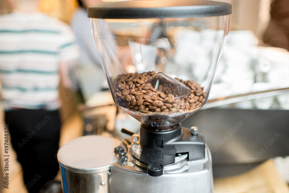 Close-up view on the coffee grinder with coffee beans in the cafe