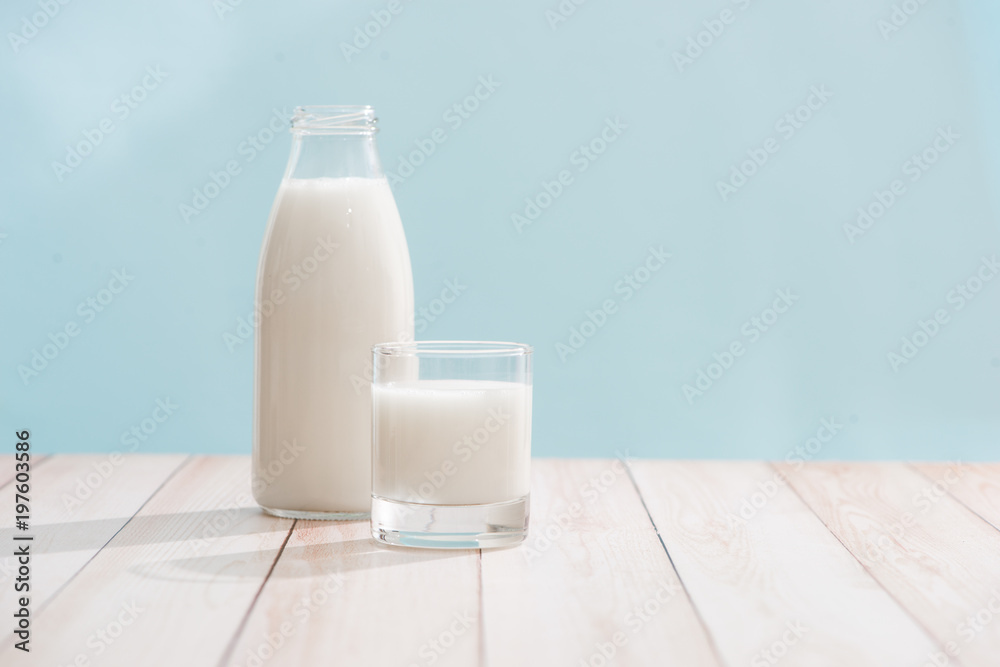 乳制品。木制桌子上的装有牛奶的瓶子和一杯牛奶