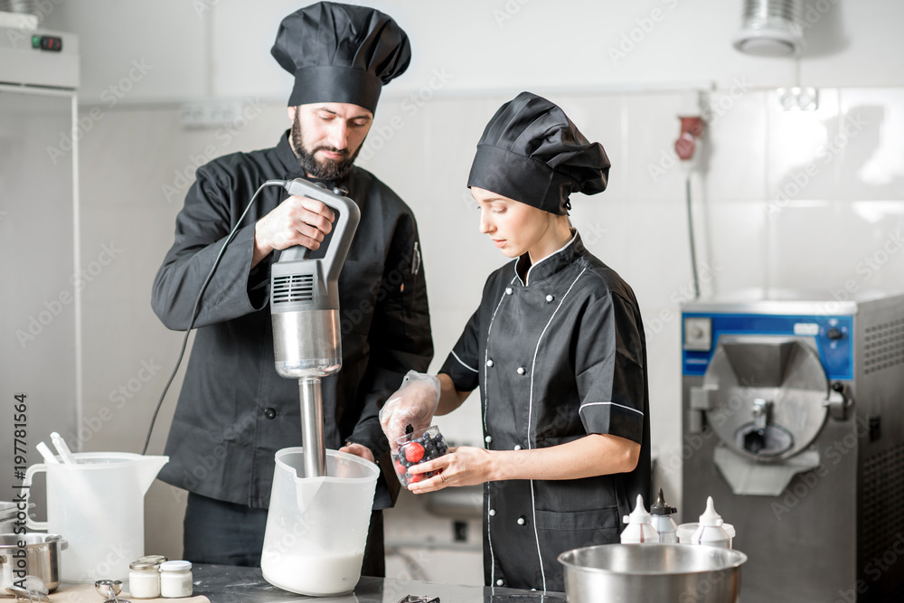 Chefs mixing berries with milk and sugar for ice cream production in the small ice cream manufacturi