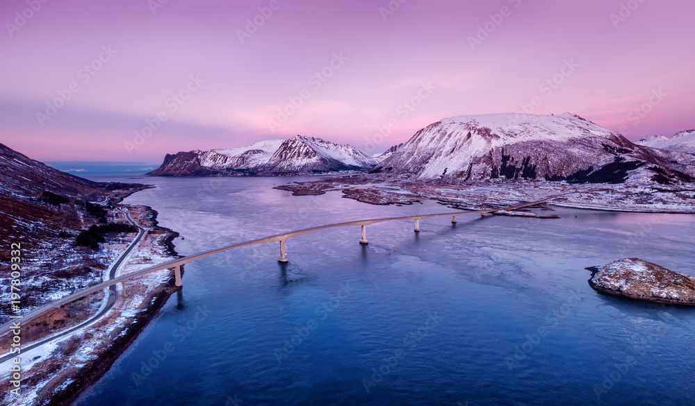 日落时的桥梁和高山。挪威的自然景观
