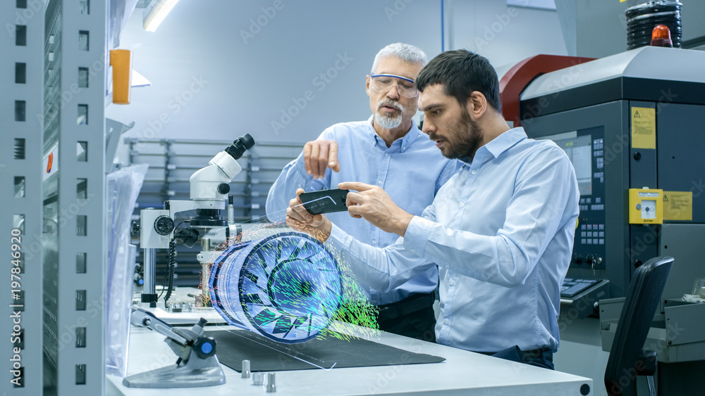 两位工程师使用增强现实全息投影3D模型处理手机