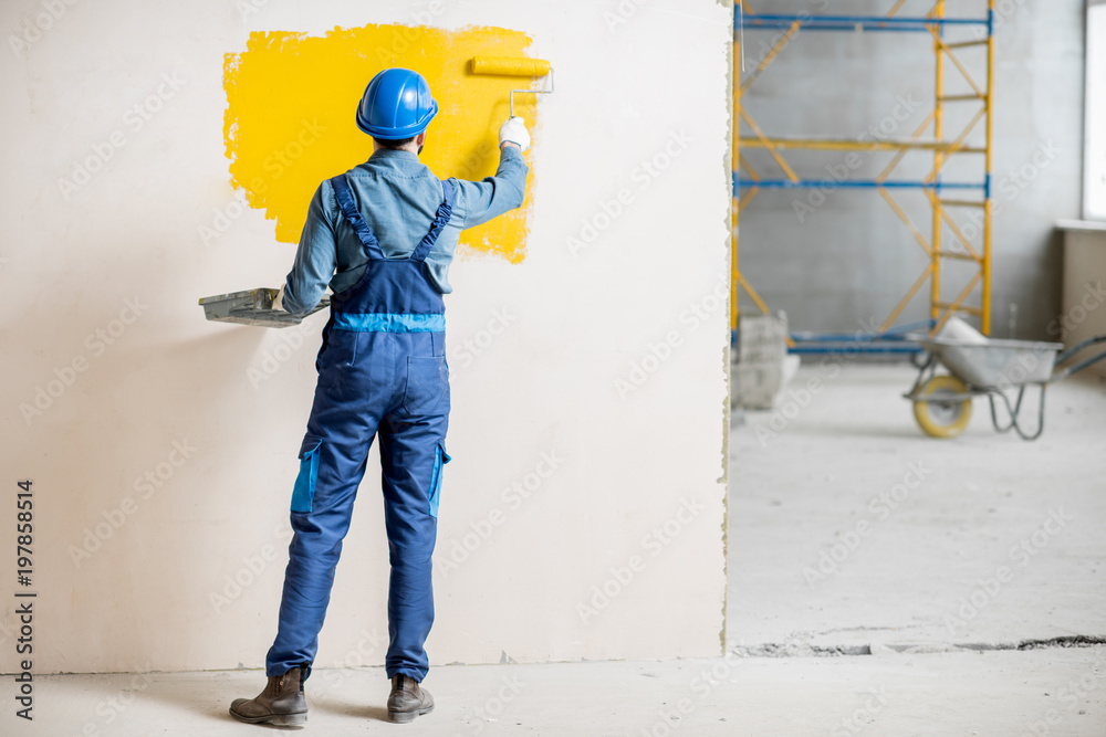 室内施工现场统一刷黄漆墙面的工人