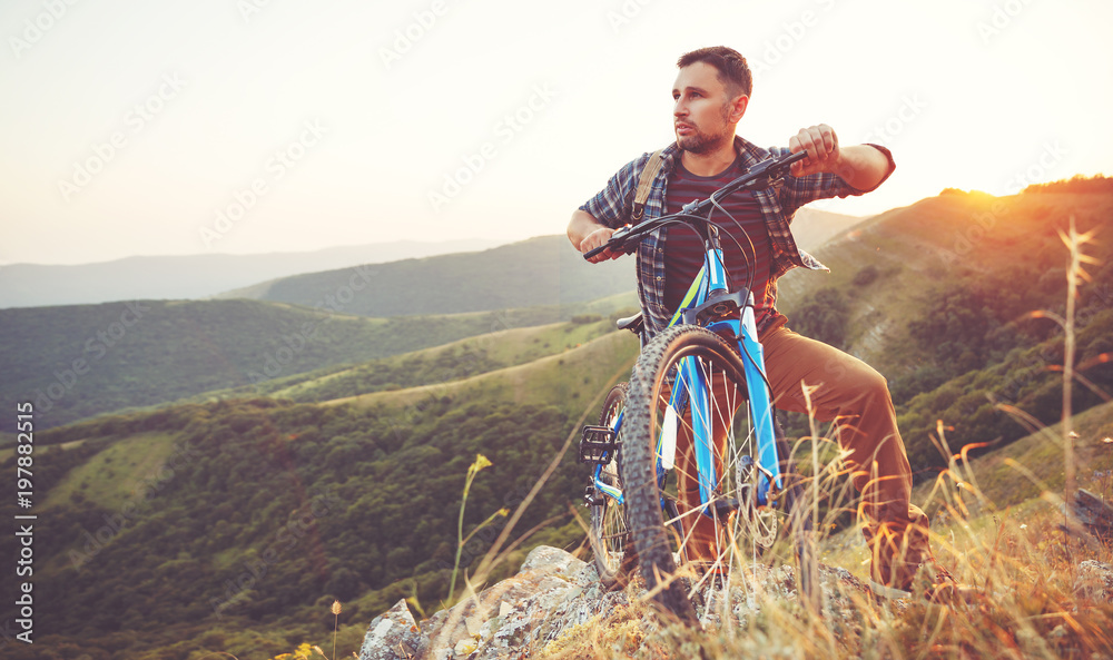 骑自行车。年轻人骑着自行车在山上的大自然中