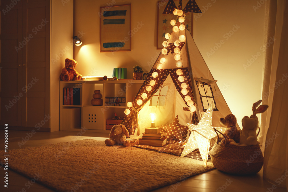 儿童游戏室内部，黑暗中有帐篷、灯具和玩具。