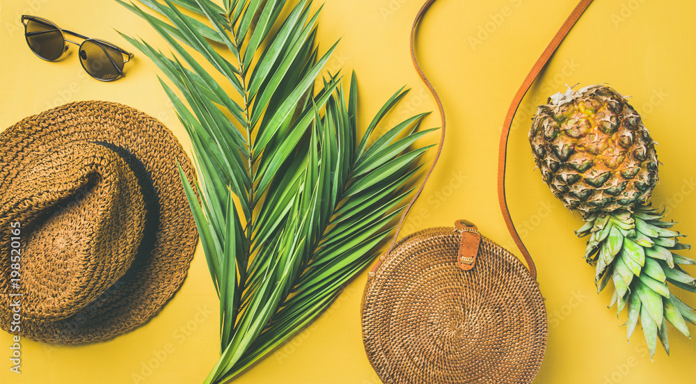 五颜六色的夏季女性时尚套装平躺。草帽、竹包、太阳镜、棕榈枝