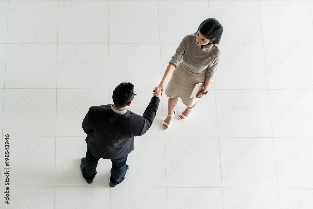 亚洲商人和女商人在办公室大厅握手的俯视图。欢迎光临商务…