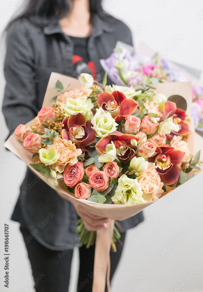 女人手里拿着一束美丽的混合花朵的奢华花束。花店花店花店的工作。a