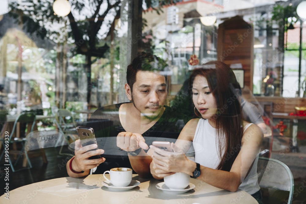 情侣在咖啡馆使用手机
