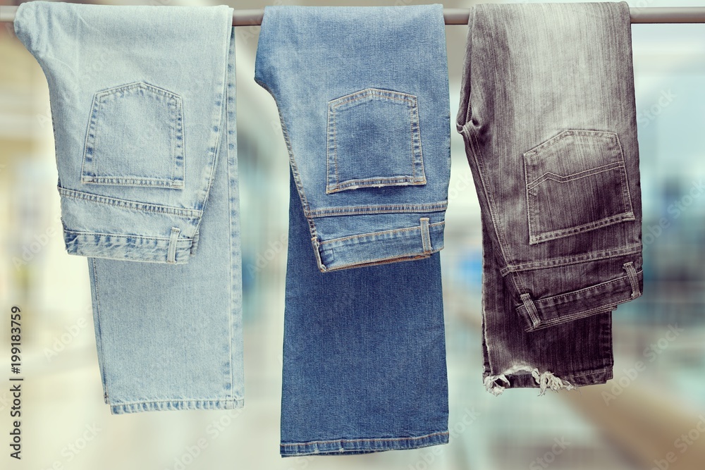 Three pair of different jeans hanging