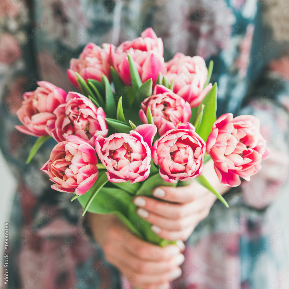 Spring flowers arrangement. Woman in colorful silk dress holding bouquet of fresh pink tulips, squar