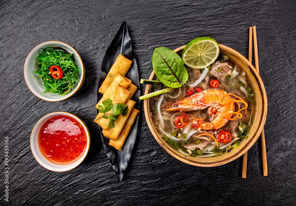 亚洲虾仁汤配春卷和筷子。