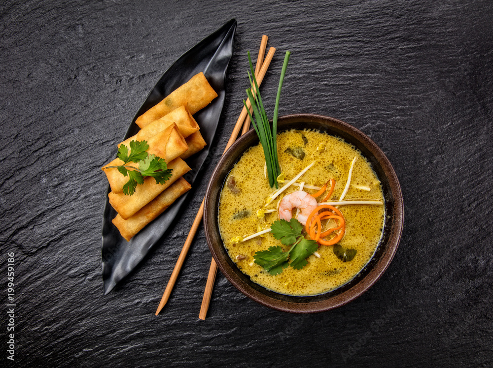 亚洲卡里汤配春卷和筷子。