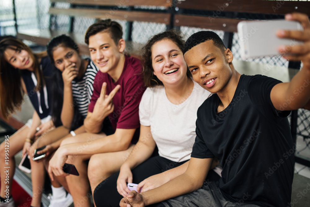 一群年轻的青少年朋友在篮球场上放松地自拍
