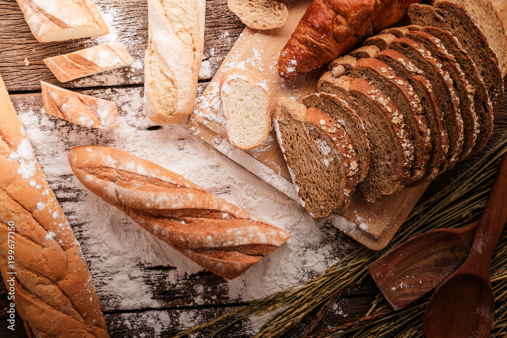 深色木桌上的新鲜烤面包，复制空间背景，小麦f静物构图