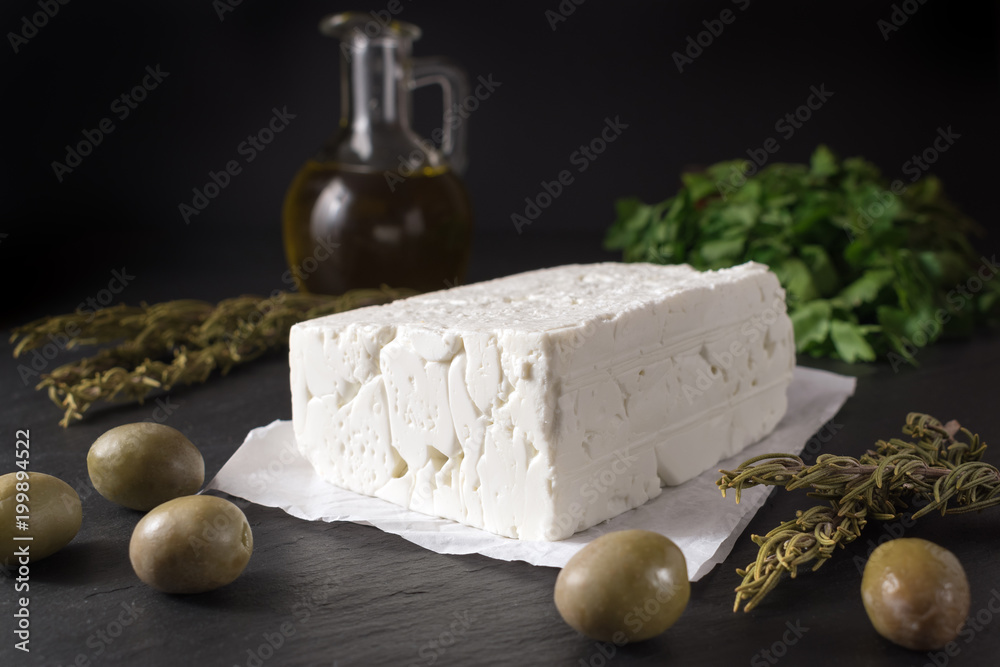 黑石板上的希腊羊乳酪，配橄榄和香草。