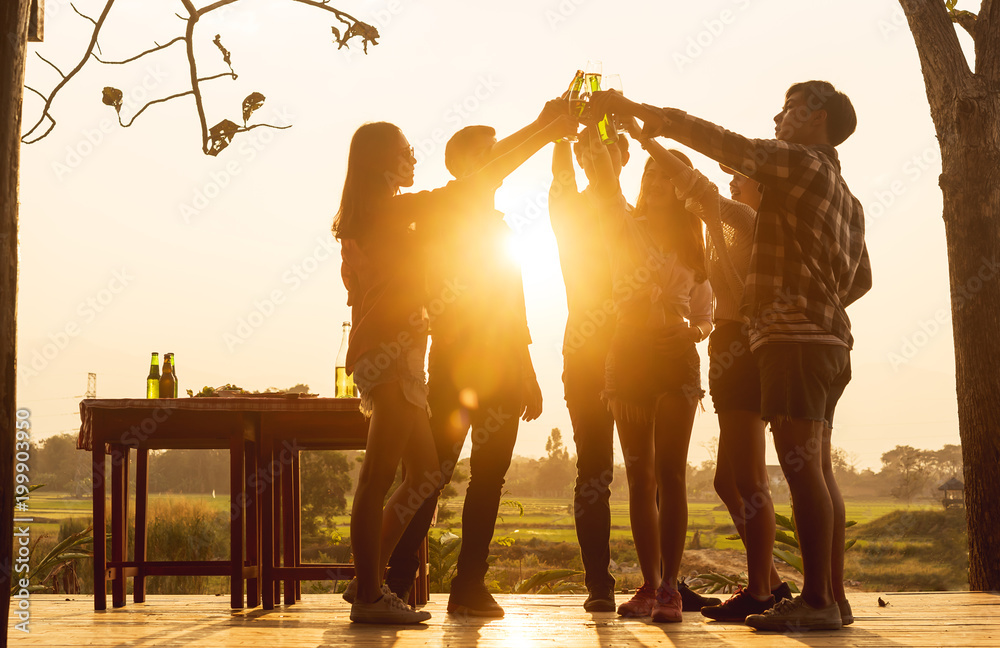 Group of 6 teenager have dinner party celebrating at sunset toasting for success