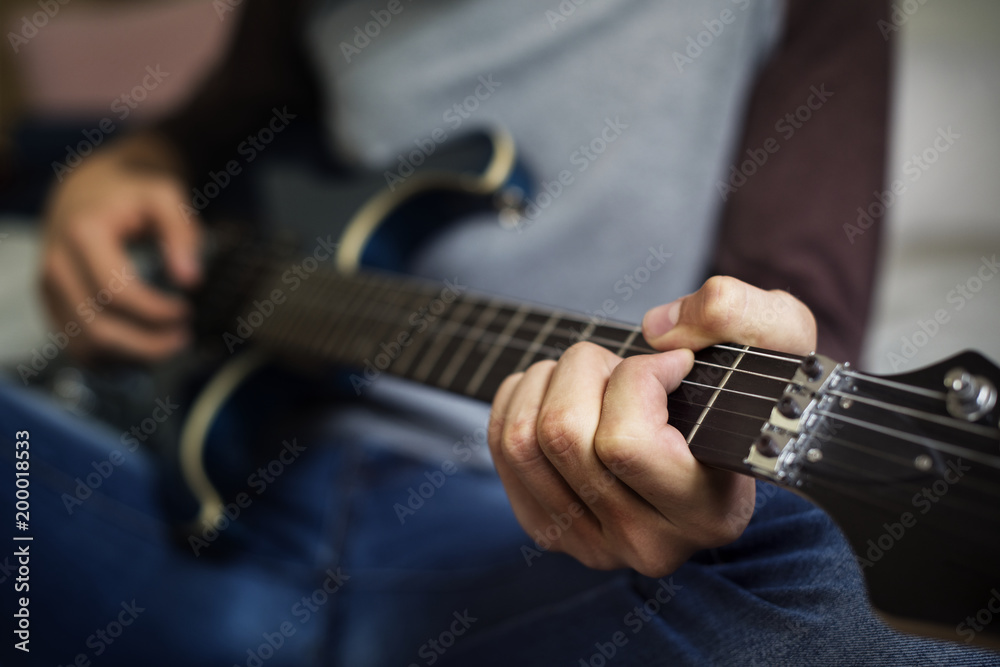在卧室爱好和音乐概念中弹电吉他的青少年男孩