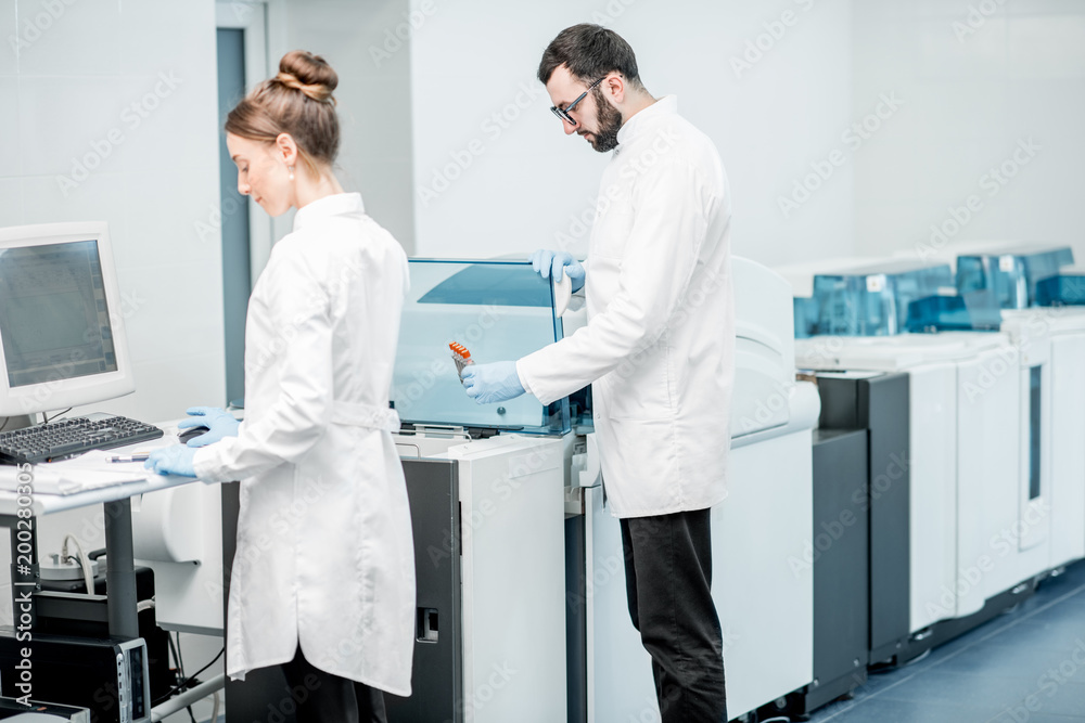两名医护人员在现代实验室配置分析仪