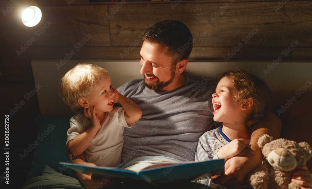 晚间家庭阅读。父亲阅读孩子。睡前读书