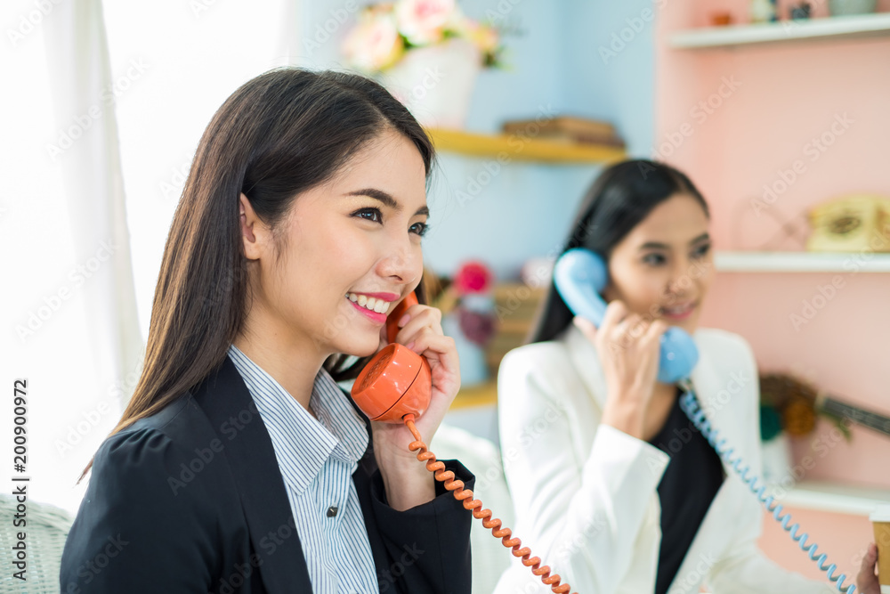 Two young asian business woman working as call center with happy and smile in office