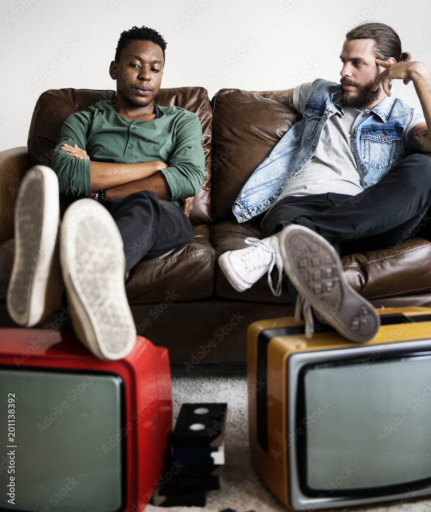 两个人坐着，两台复古电视