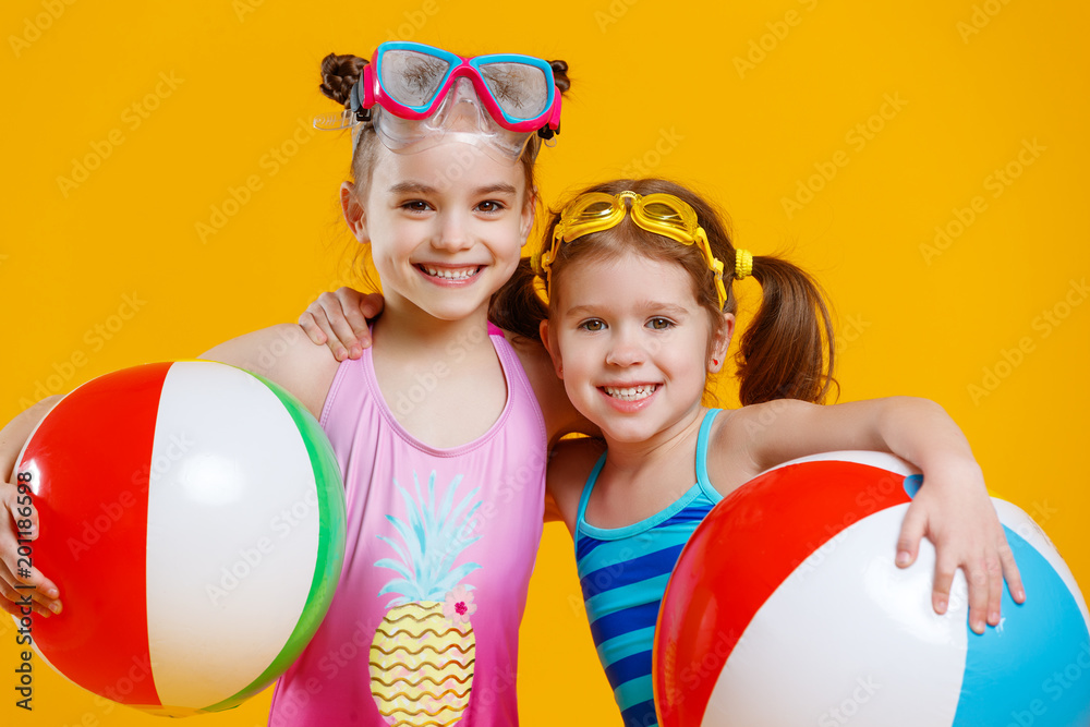 有趣有趣快乐的孩子穿着泳衣，戴着彩色背景的泳镜