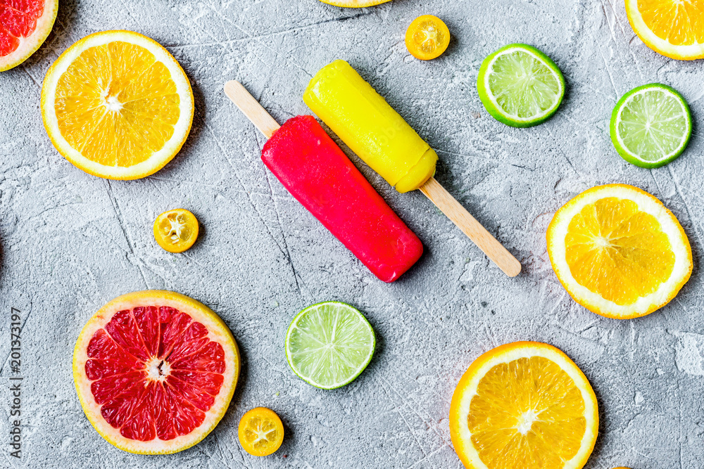 citrus slices with fruit popsicles on table background top view 