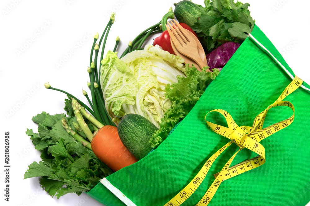 在白色、健康的有机绿色食品上关上一袋混合有机绿色蔬菜的绿色食品袋