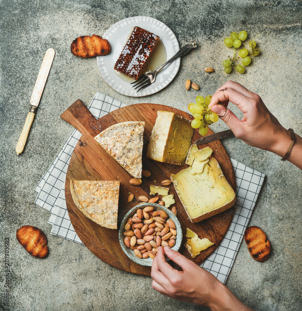 扁平奶酪拼盘，配各种奶酪、绿葡萄、面包、蜂蜜和坚果，配女性h
