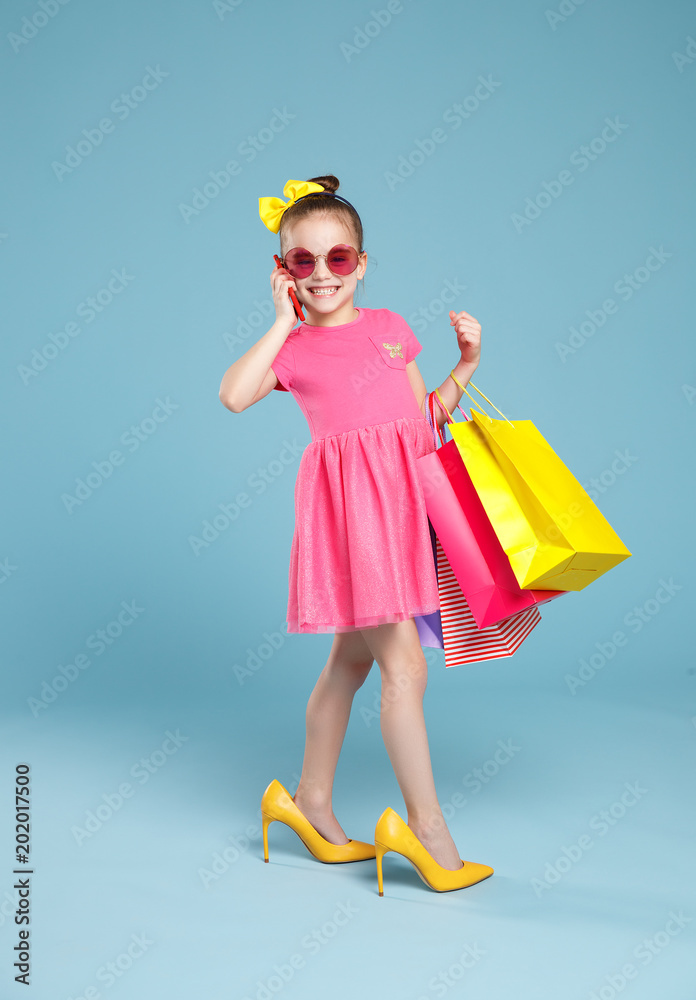 有趣的童女时尚达人，穿着彩色背景的大妈妈鞋
