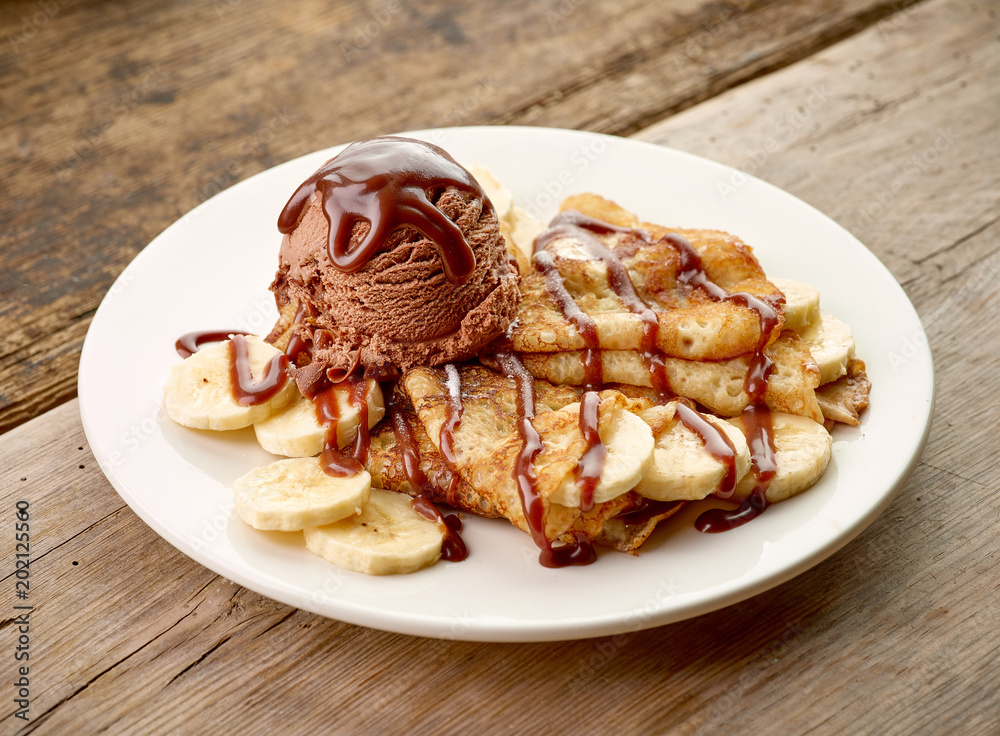 木制桌子上的香蕉和巧克力冰淇淋拼盘