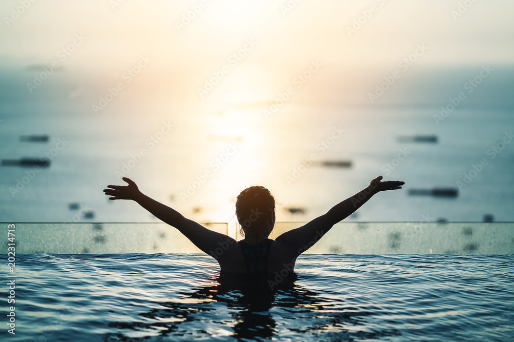 亚洲女性的黑色轮廓在暑假假期泼水，穿着无边泳衣放松