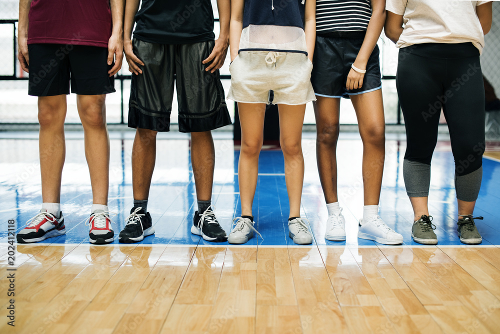 一群年轻的青少年朋友站在篮球场上，排成一排