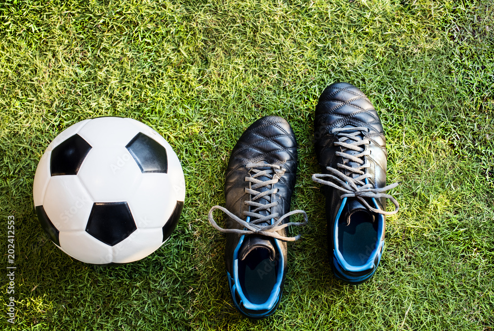 草地上足球和足球鞋的特写