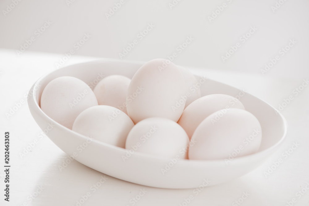 木桌上的白色盘子里的鸡蛋